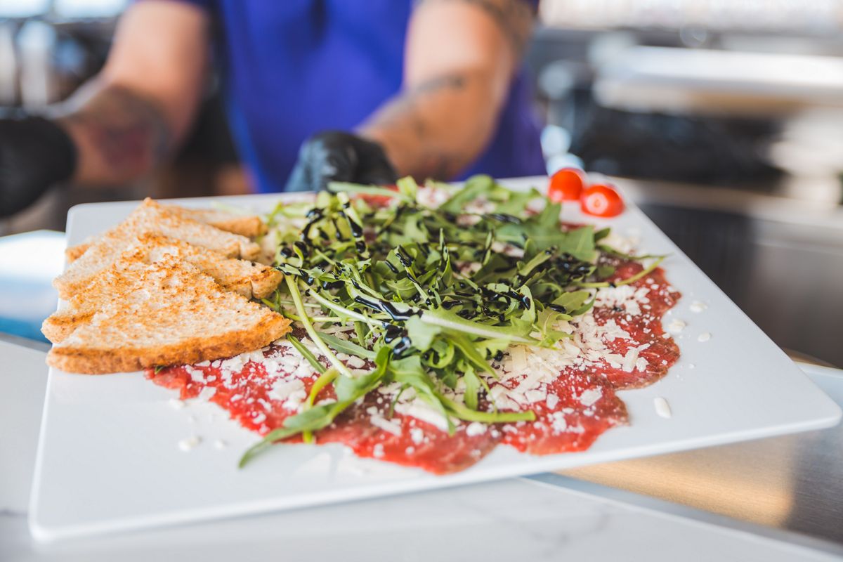 Beef carpaccio with arugula and toasted bread in a restaurant in Tenerife.