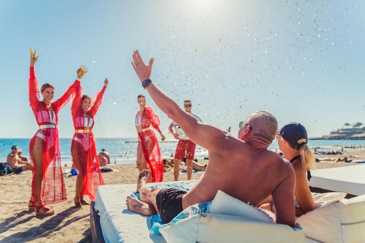 People enjoying the beach with dancers in Puerto de la Cruz, Tenerife.