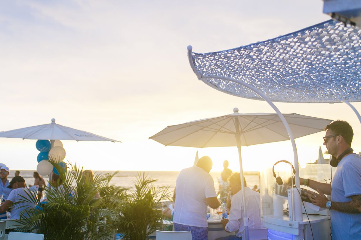 People enjoying themselves on a terrace by the sea in Tenerife at sunset.