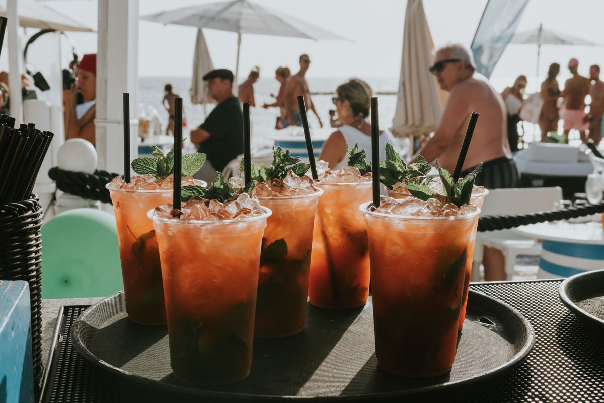 Glasses of cocktails with mint and ice on a busy beach in Tenerife.