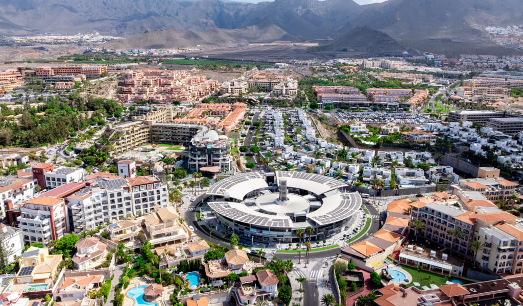 Aerial view of Costa Adeje in Tenerife with buildings and mountains in the background.