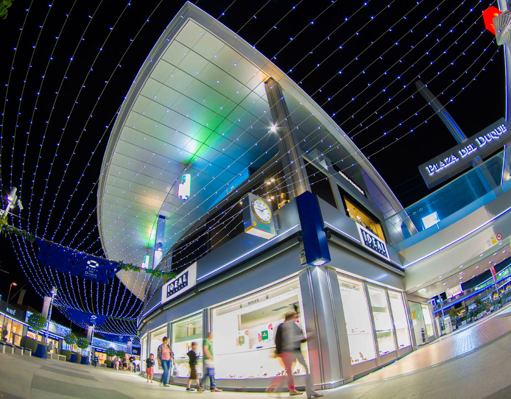 Plaza del Duque shopping centre in Tenerife illuminated at night.