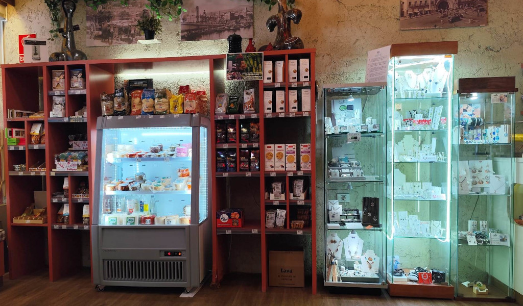 Shelves with snacks, fridge with dairy products and display cabinets with jewellery in a store in Tenerife.