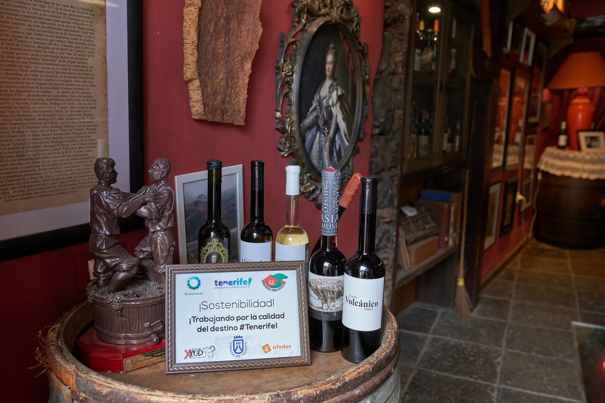 Bottles of wine and sustainability sign on barrel in a Tenerife establishment.