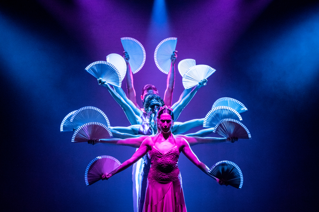 Dancers on stage with illuminated fans at a show in Tenerife.