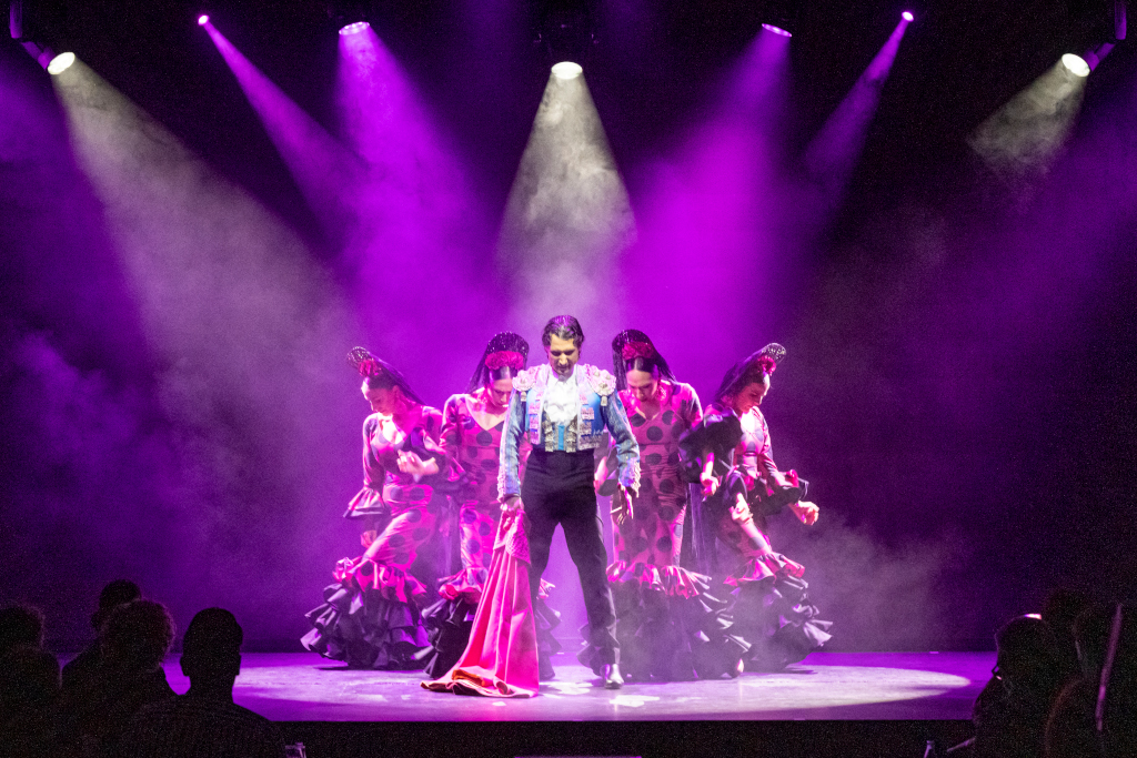 Group of flamenco dancers on an illuminated stage in Tenerife.