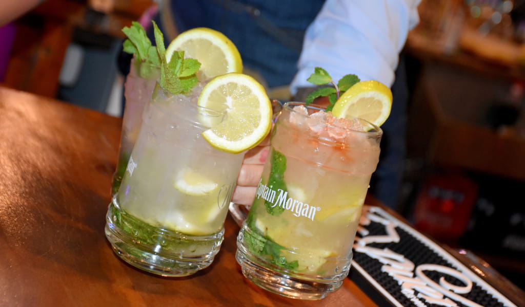 Two cocktails with lemon and mint slices in Captain Morgan glasses in a bar in Tenerife.