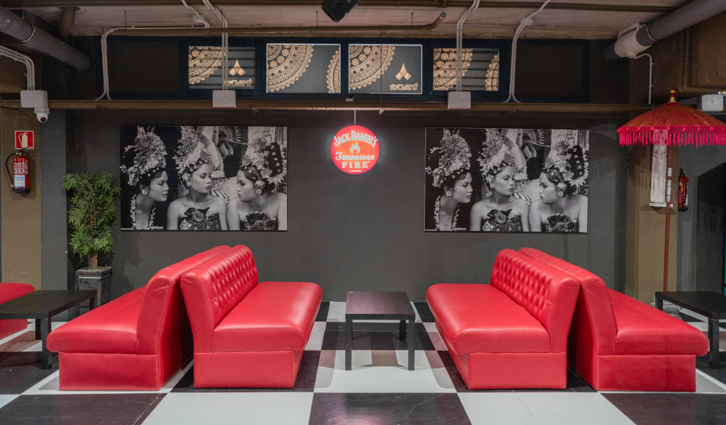 Red sofas in front of photos of traditional dancers and Jack Daniel's sign in Santa Cruz de Tenerife.