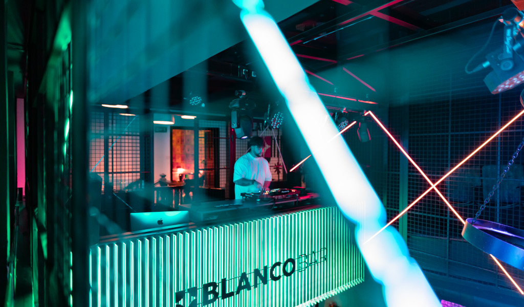 DJ playing music at Blanco Bar, Tenerife, lit up with neon lights.