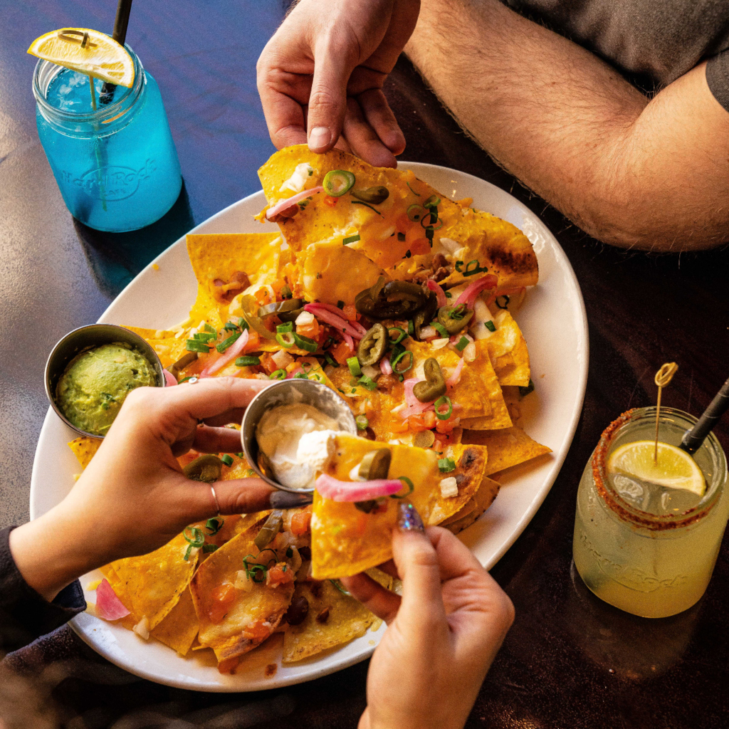 Nachos with guacamole and sour cream in a restaurant in Tenerife, accompanied by drinks.