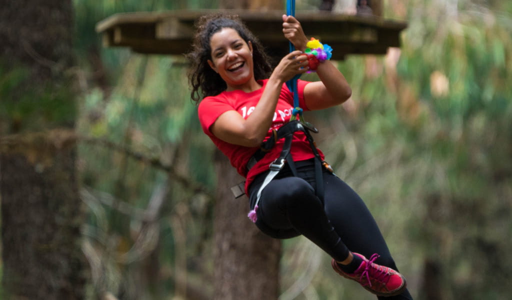 Person enjoying a zip line ride in a forest in Tenerife.
