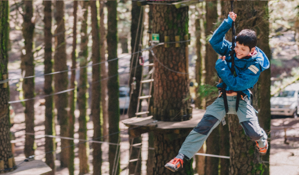 Boy enjoying zip line in adventure park in Tenerife.
