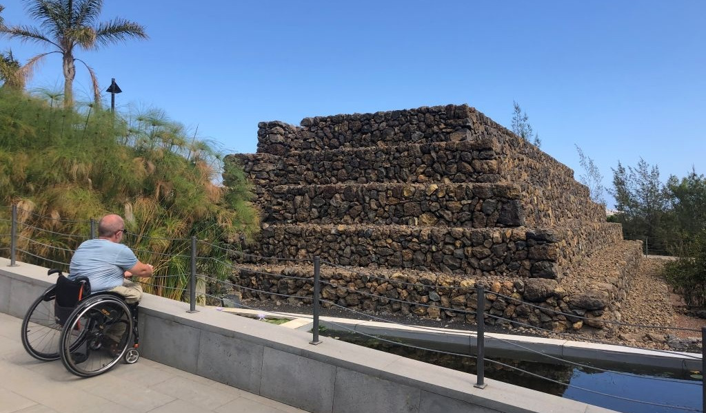 Person in a wheelchair looking at a pyramid in Güímar, Tenerife.