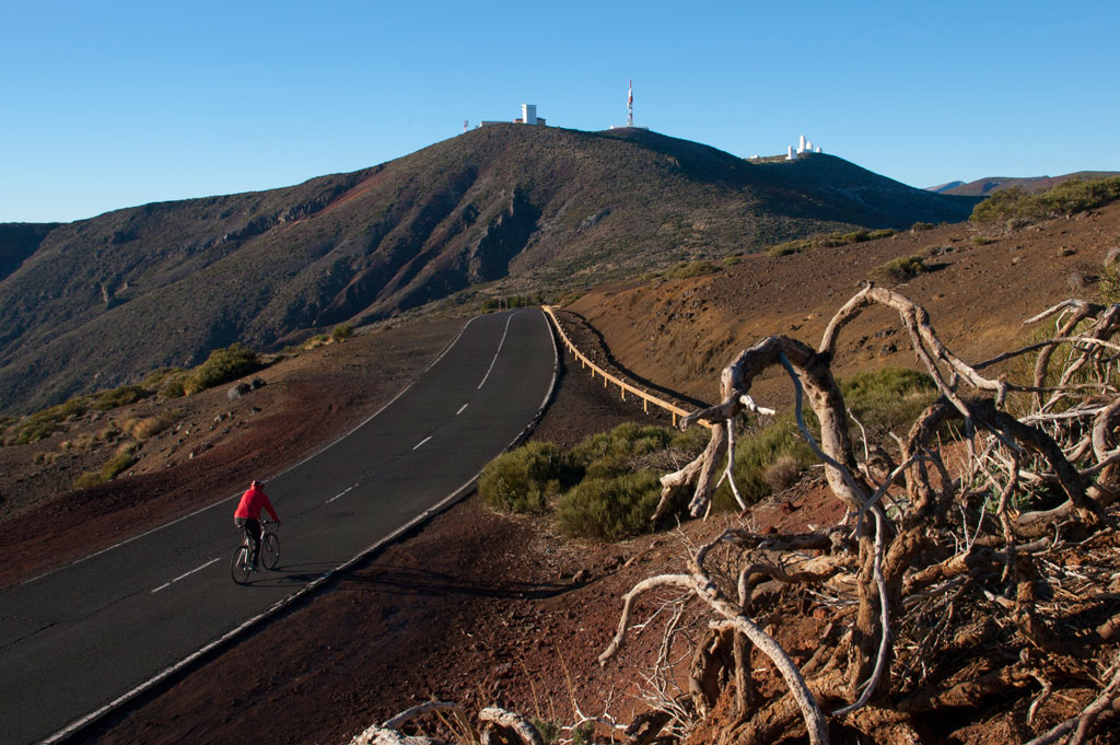Road cyclist in Teide National Park, Tenerife, with hills in the background.