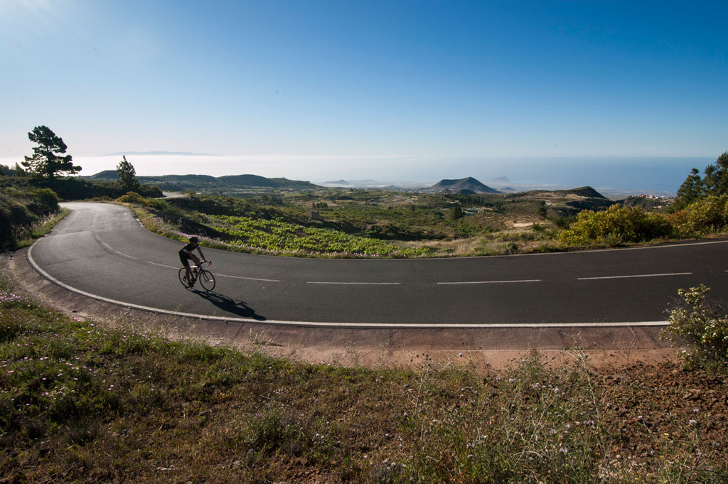 Cyclist on a road overlooking the mountainous landscape of Tenerife.