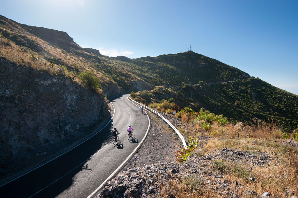 Cyclists climbing a road in the mountainous landscape of Tenerife.