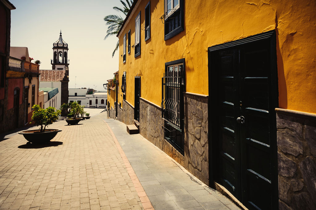 Cobbled street and colorful buildings in La Orotava, Tenerife. Church tower in the background.