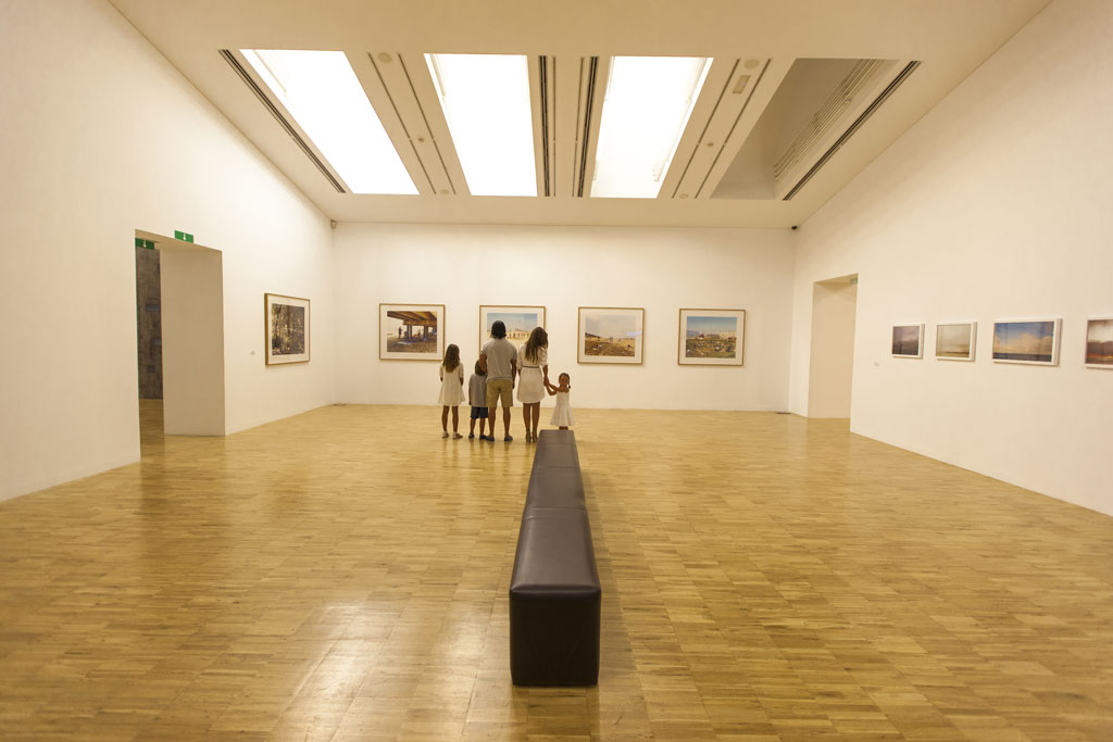 Family looking at paintings in an art gallery in Santa Cruz de Tenerife.