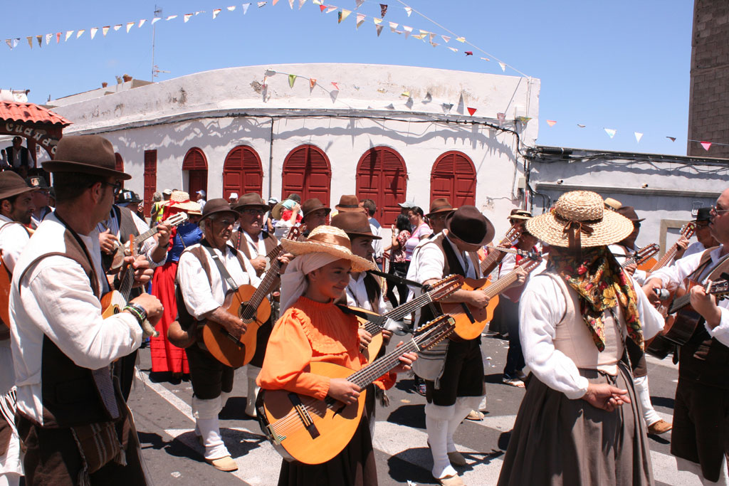 Group of people in traditional costumes playing guitars at a party in Tenerife.