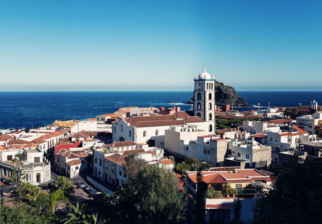 Panoramic view of Garachico, Tenerife, with sea in the background and historic buildings.