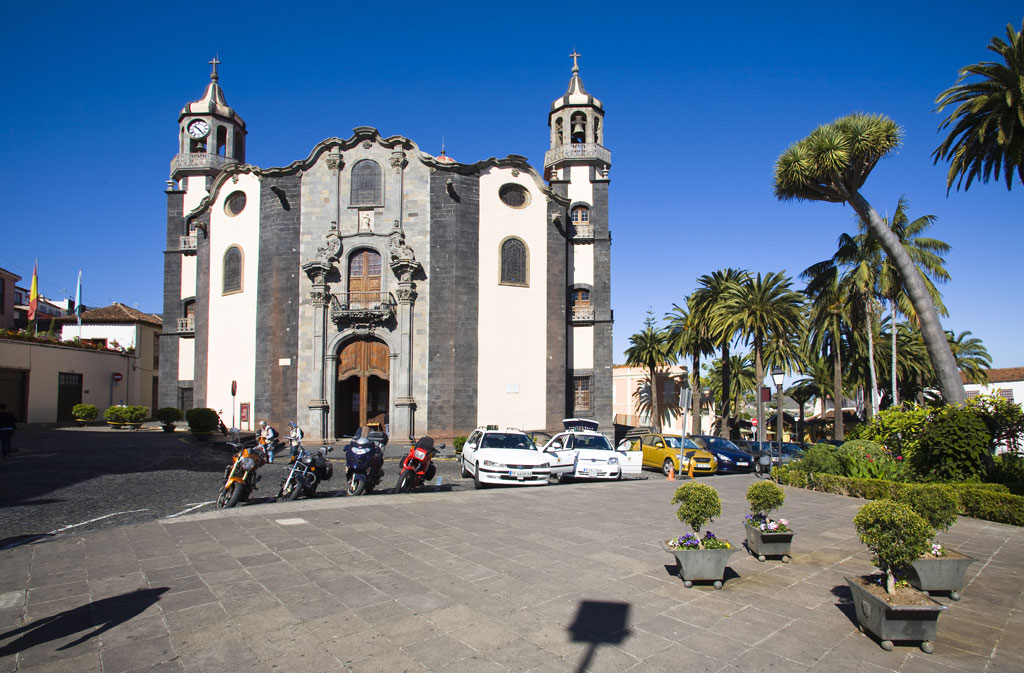 Church with cars and motorcycles parked in front of its façade in La Orotava, Tenerife.