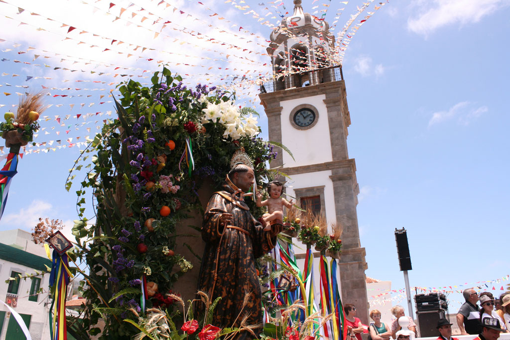 Party in La Orotava with clock tower and festive decoration.