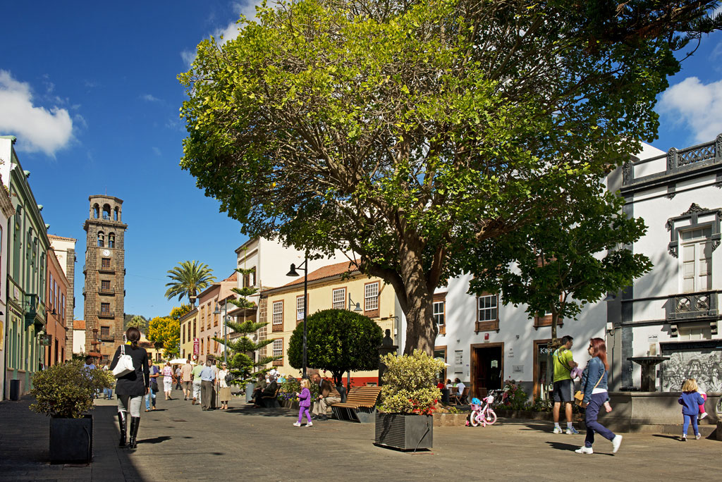 People walking in the square with church tower in La Laguna, Tenerife.