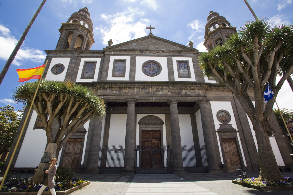 Cathedral of San Cristóbal de La Laguna with dragon tree and flags.