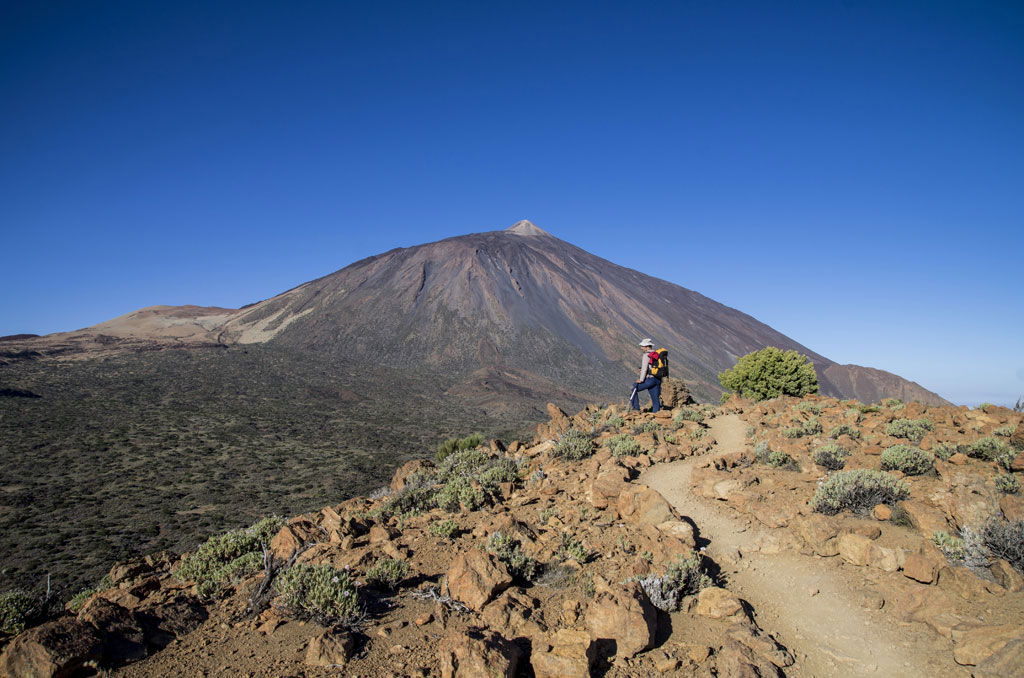 Hiker in the Teide National Park, Tenerife, with the volcano in the background.