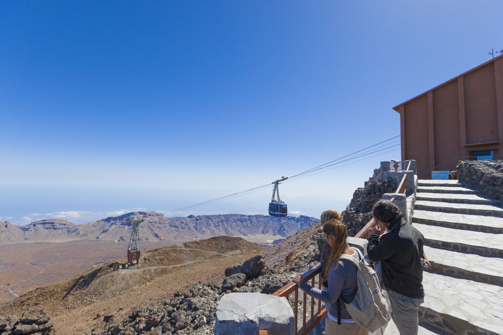 Cable car on Mount Teide, Tenerife, with tourists watching the mountains and scenery.