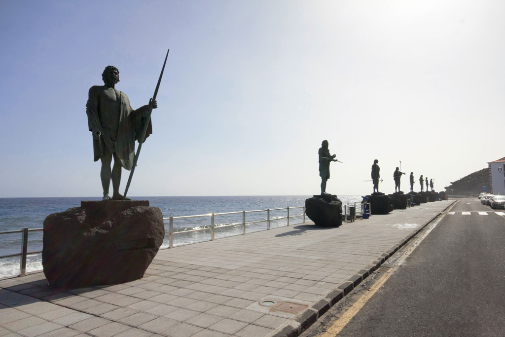 Guanche statues lined up by the sea in Candelaria, Tenerife.
