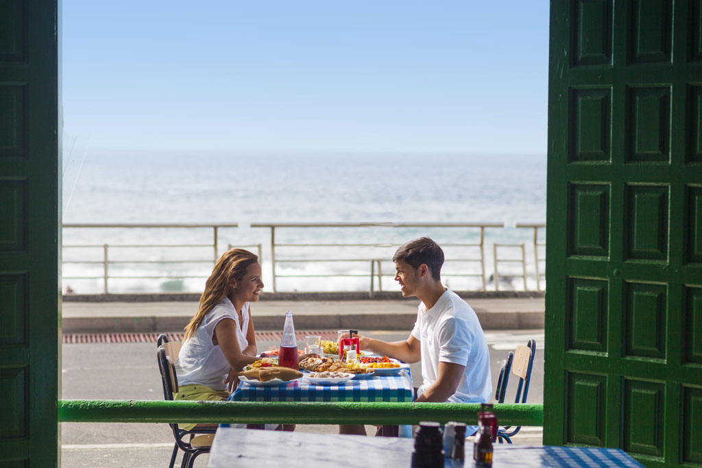 Couple eating on a terrace overlooking the sea in Tenerife.