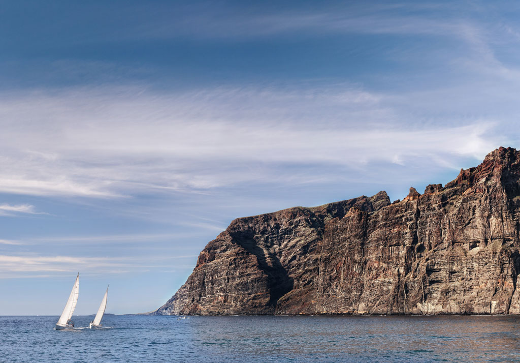 Sailboats sailing in front of the cliffs of Los Gigantes, Tenerife.