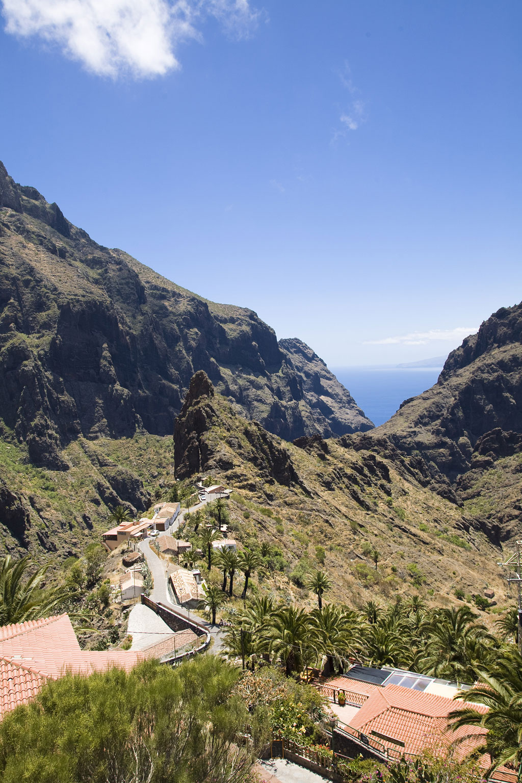 Valley and houses in the Masca ravine, Tenerife, with the ocean in the background.