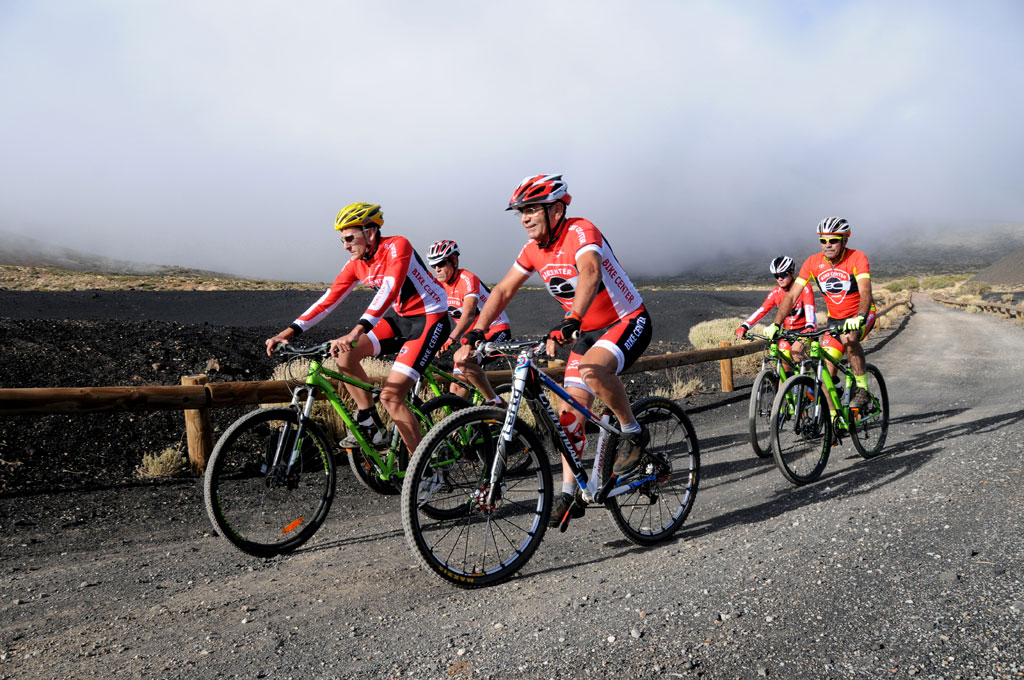Cyclists on a mountain road in Tenerife, dressed in red and black uniform.