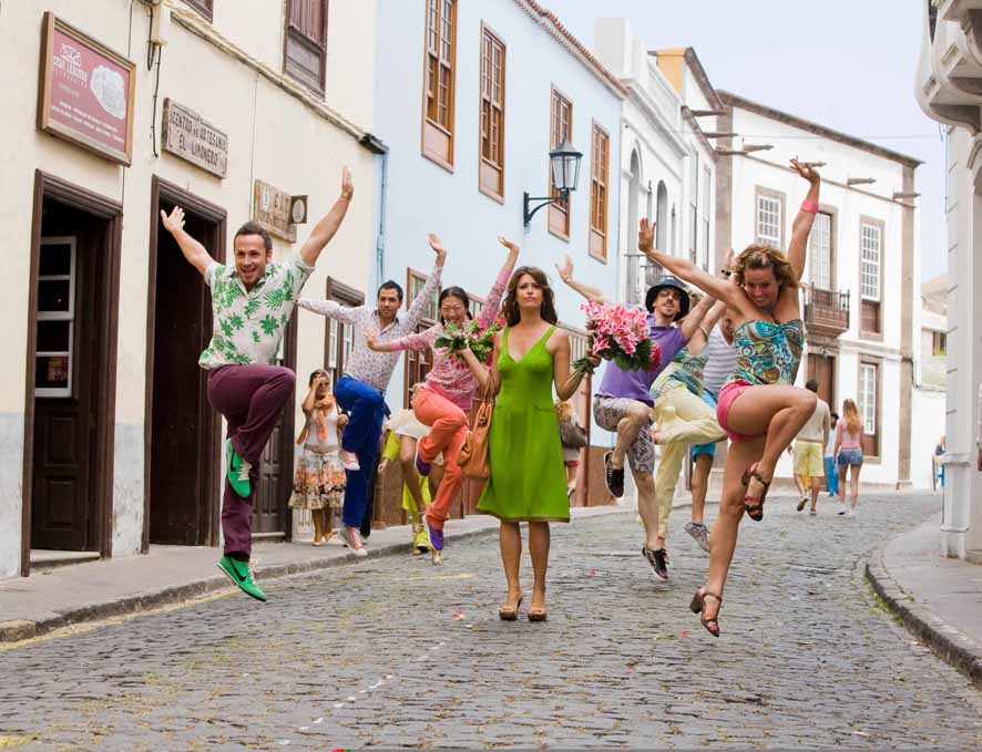 People dancing on a street in La Laguna, Tenerife, with flowers and colorful clothes.