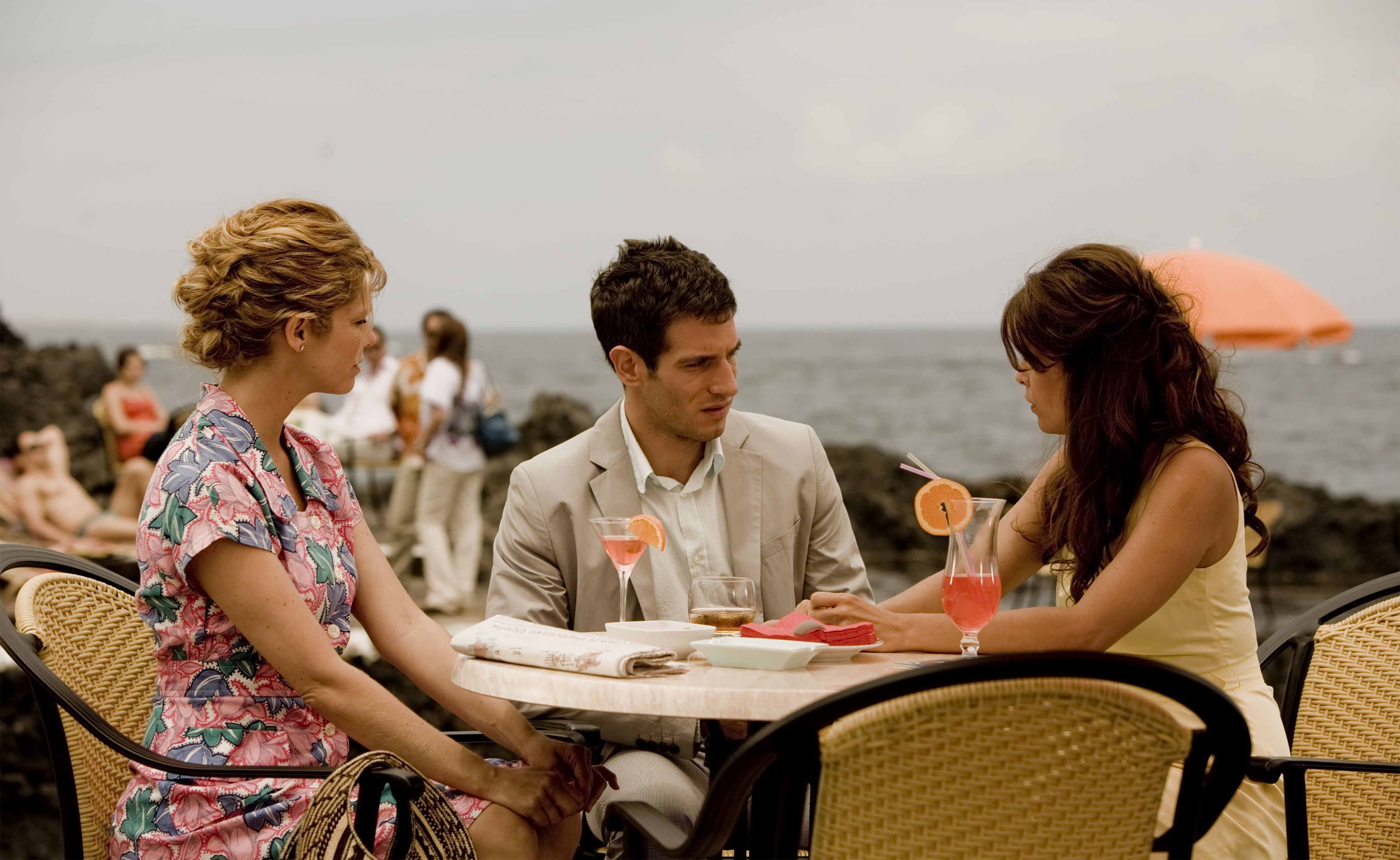 People chatting on a terrace by the sea in Tenerife. Drinks at the table.