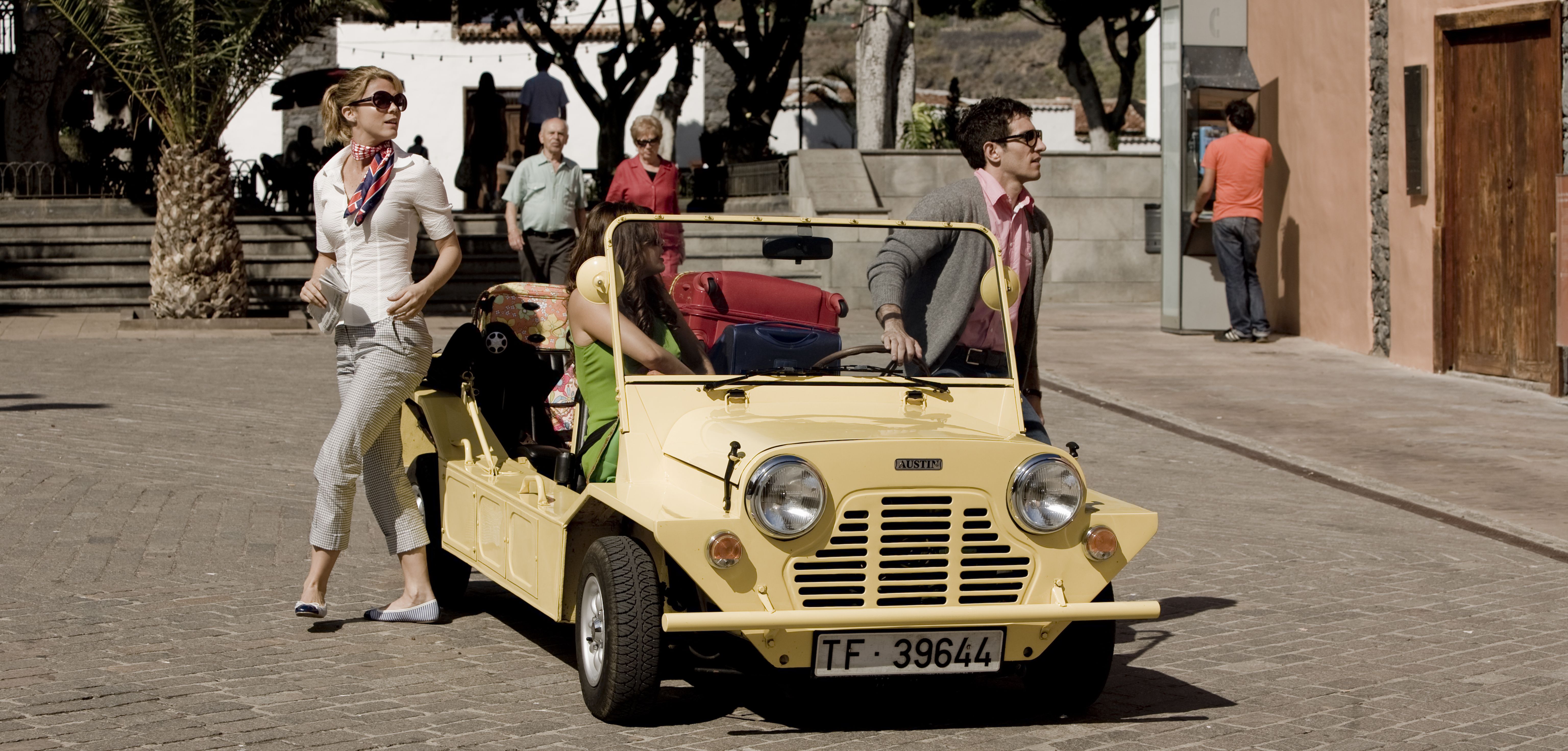 Woman and man next to yellow convertible car in Tenerife.