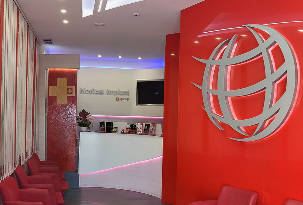 Medical Implant Group reception with red chairs and logo in Santa Cruz, Tenerife.