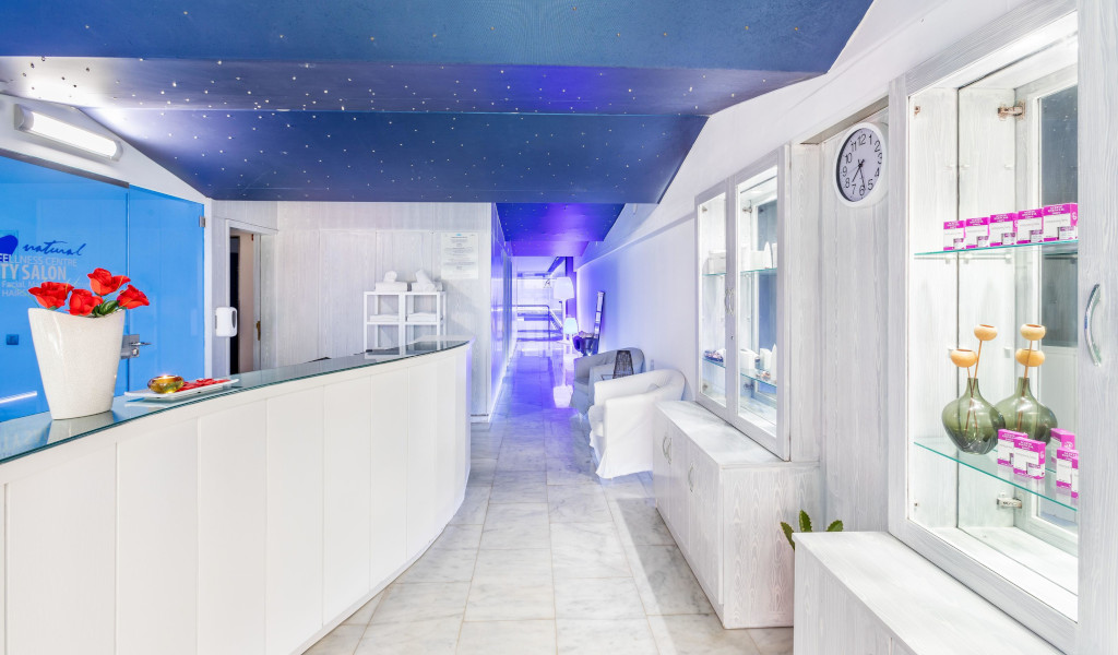 Reception of a wellness center in Tenerife with red flowers on the counter.