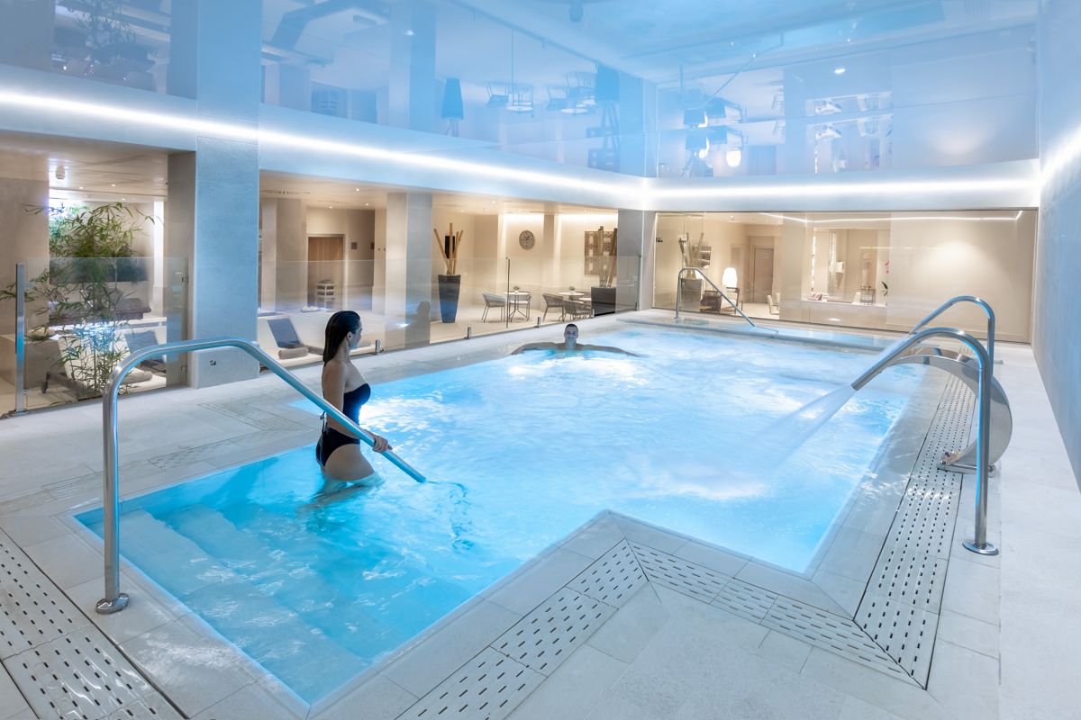 Indoor swimming pool in a spa centre in Tenerife with two people enjoying themselves.
