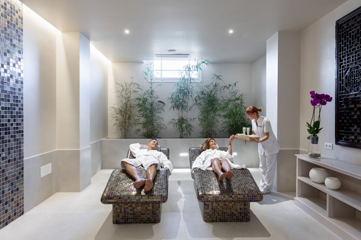 People relaxing in a spa in Tenerife with a glass of drink.
