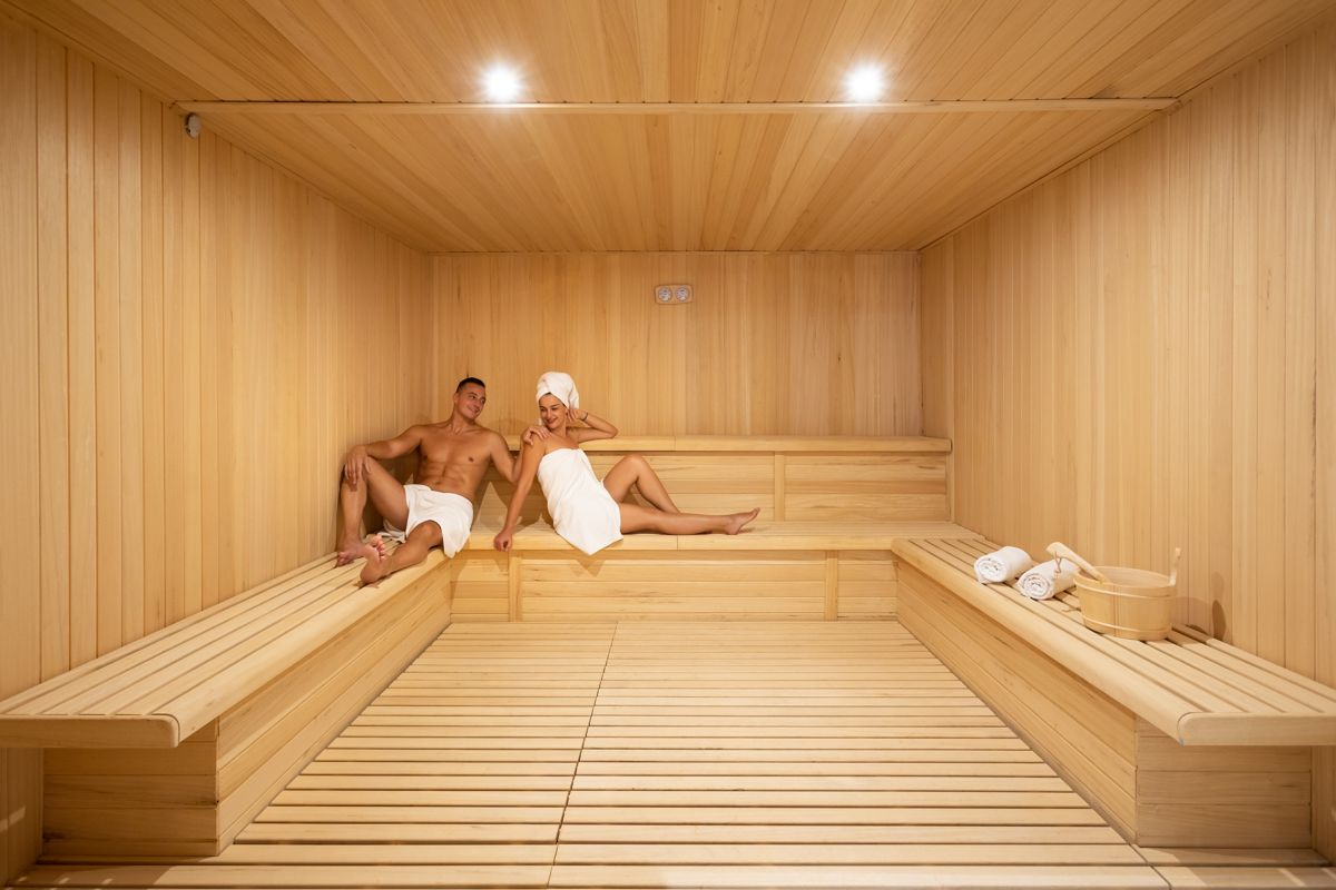 People relaxing in a wooden sauna with towels in Tenerife.