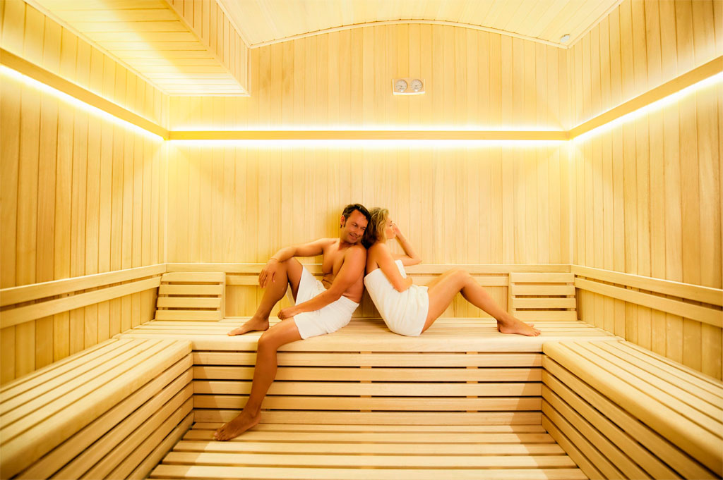 Couple relaxing in a wooden sauna at a spa in Tenerife.
