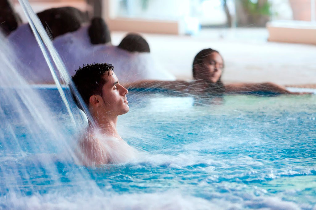 Man enjoying a jet of water in a swimming pool in Tenerife.