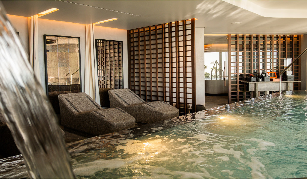 Indoor pool with relaxation loungers and decorative walls in Tenerife.