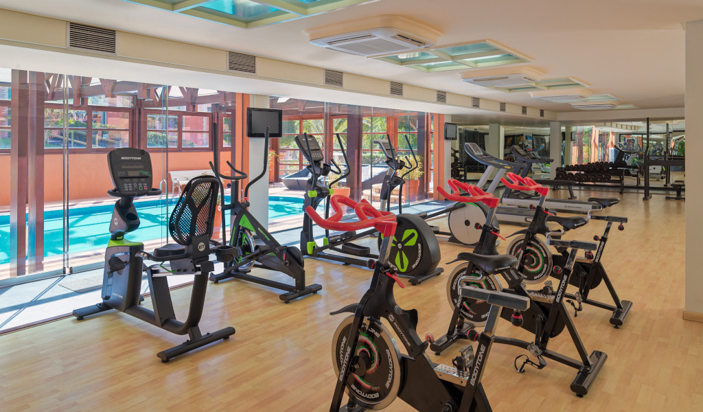 Gym with modern equipment and view of the pool in Tenerife.