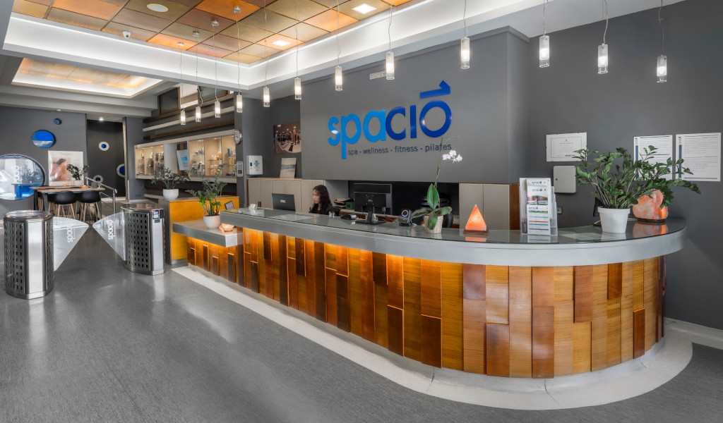 Reception of the Spacio spa in Tenerife with a person working and a decorative plant.
