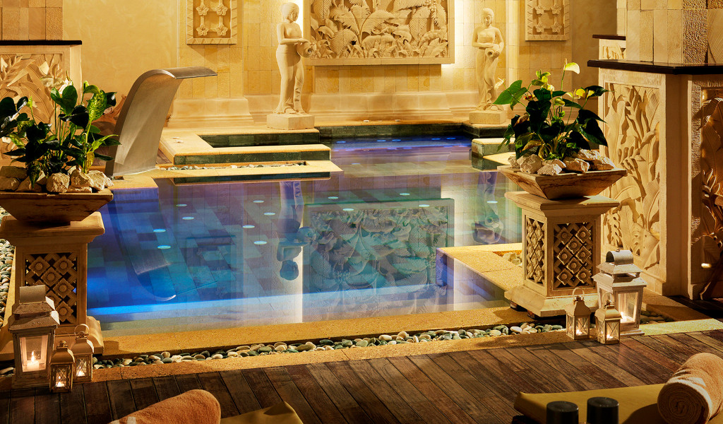 Swimming pool decorated with sculptures and plants in a spa in Tenerife.