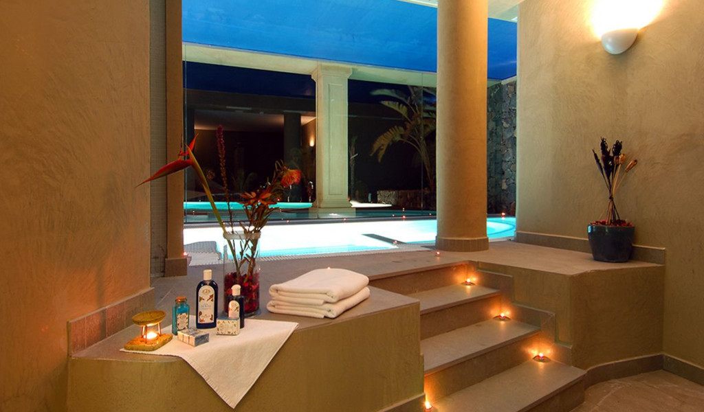 Indoor swimming pool with flowers, towels and candles in Tenerife resort.